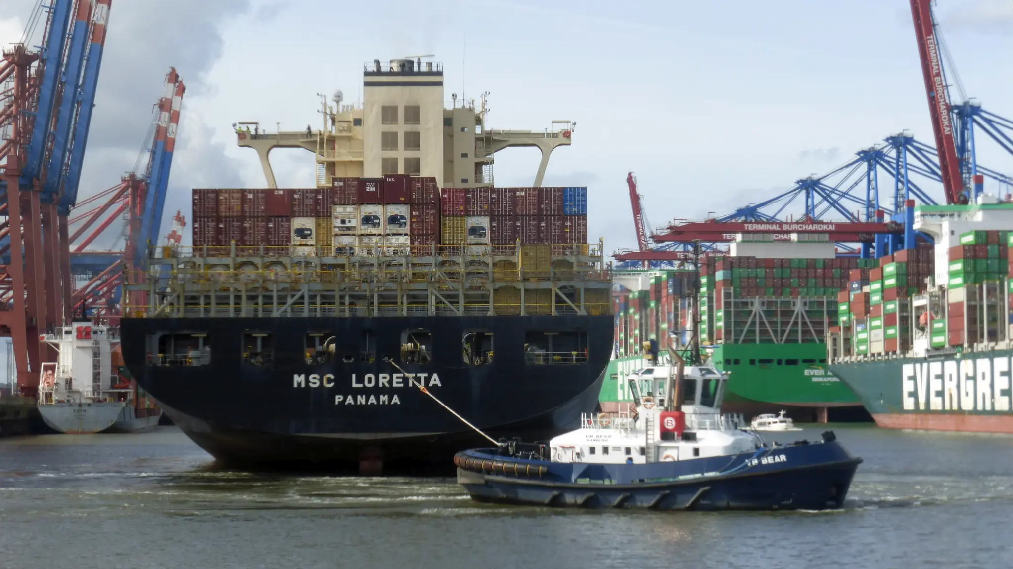 Schlepper und Containerschiff im Hafen Waltershof